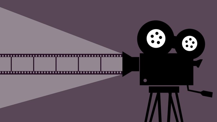 En filmkamera med filmrulle på træstativ.
