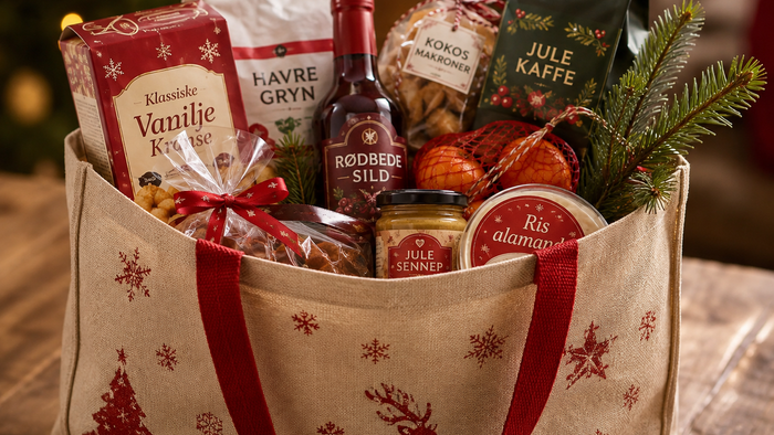 En festlig gavekurv fyldt med julegodter, snacks, kaffe og en flaske vin.
