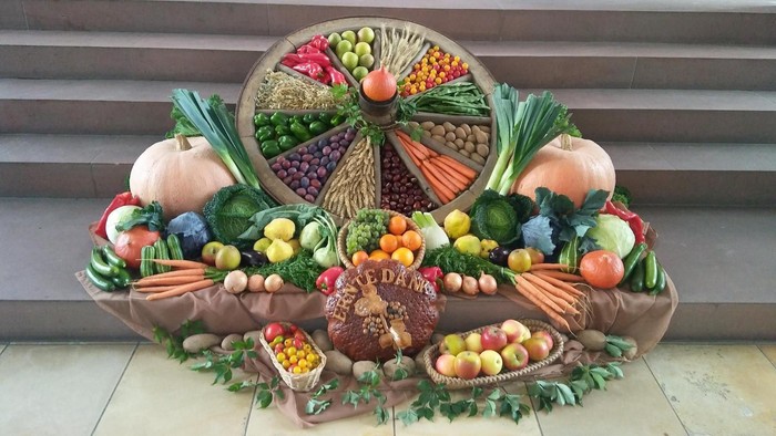 Bunte Erntedank-Dekoration mit verschiedenen Früchten, Gemüsesorten und einem Füllhorn als Symbol für Fülle und Überfluss.