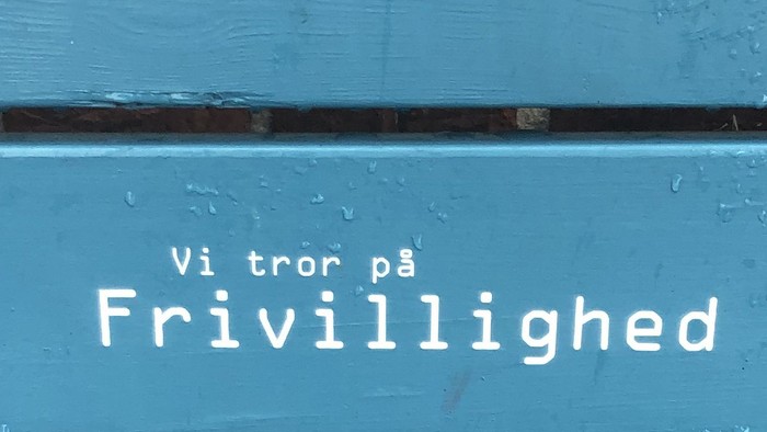 Blå dør med skrift 'Vi tror på Frivillighed'