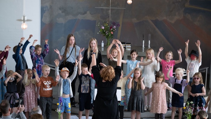 En gruppe børn og voksne danser i en kirke