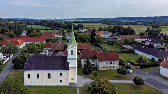 Luftaufnahme einer kleinen Stadt mit einer markanten Kirche und umliegender Landschaft