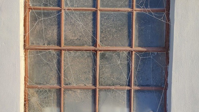 Knust vindue med revnede glasruder.