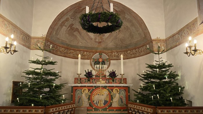 Indre del af kirke med juletre og hængende krans