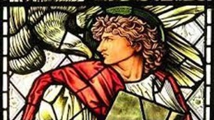 Stained glass af en mand i rød og hvid kappe med vingesymbol.
