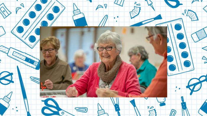 Eine Gruppe älterer Menschen genießt eine Bastelstunde mit verschiedenen Kunstmaterialien um sich herum.