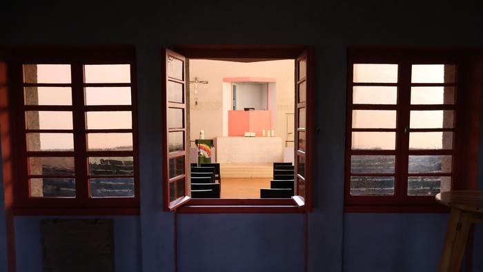 Helles Innenraumzimmer, durch offene Fenster mit malerischem Blick nach draußen sichtbar.