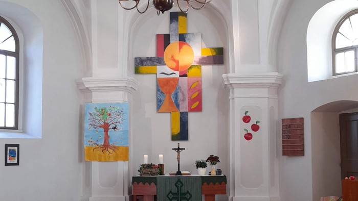 In der Kirche hängen farbenfrohe Kreuz und Kronleuchter