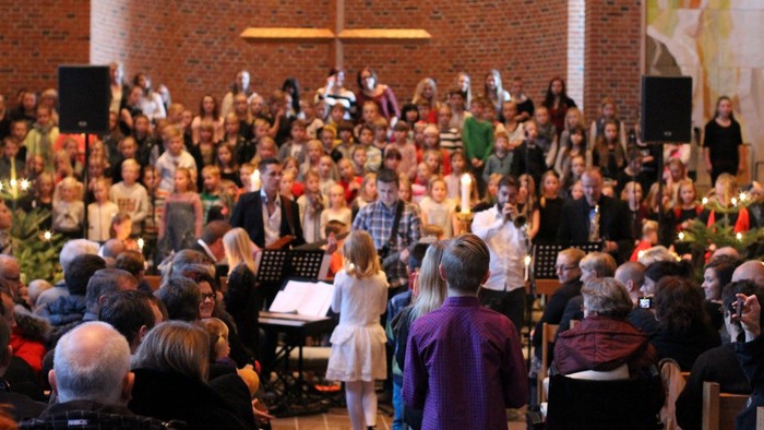 En stor kirkefuld med folk under en gudstjeneste