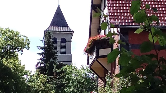Ein hübsches Haus mit Blumenkästen und eine Kirche im Hintergrund