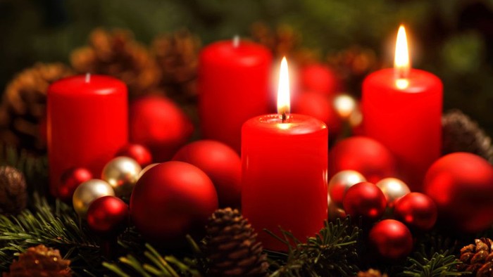 Weihnachtsdekoration mit roten Kerzen und Christbaumkugeln