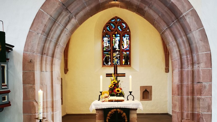 Gotteshaus mit Altar und Buntglasfenster