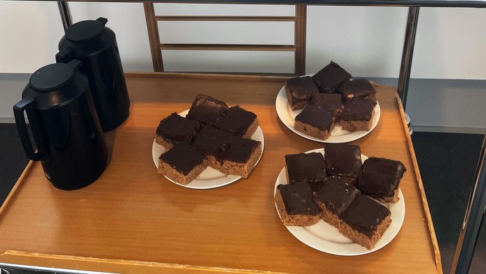 Et selvbetjenings-dessertbord med chokoladekager og kaffe tilgængelig til køb via MobilePay.