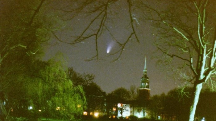 Nachtszene mit beleuchteter Straße und Kirche im Hintergrund