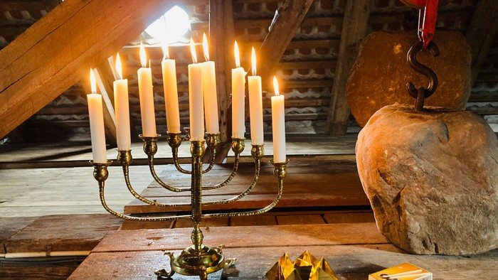 En jødisk menora med lysede lygter på en bord med juledekor.