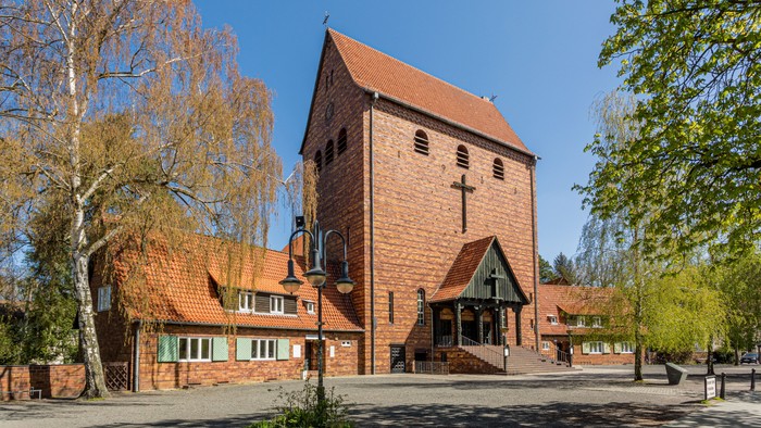Kirchengelände mit Hauptgebäude und Bäumen unter klarem Himmel