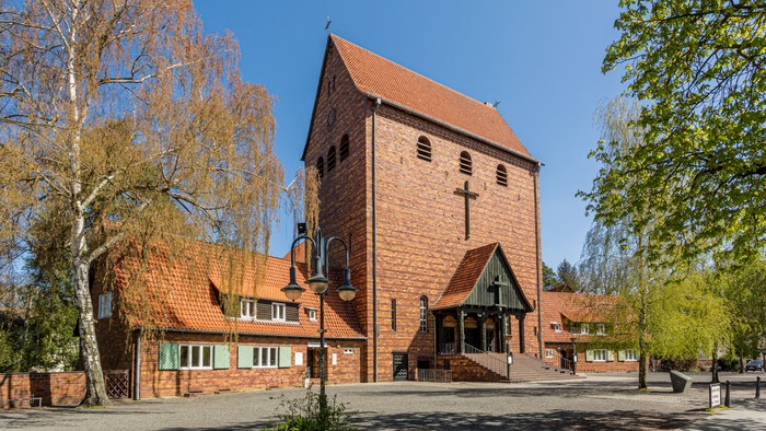 Kirchengelände mit Hauptgebäude und Bäumen unter klarem Himmel