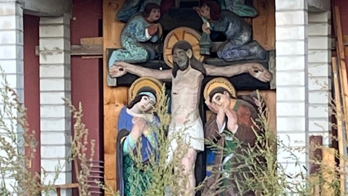 Kreuzigungsszene mit Jesus und umstehenden Figuren im Freien dargestellt.