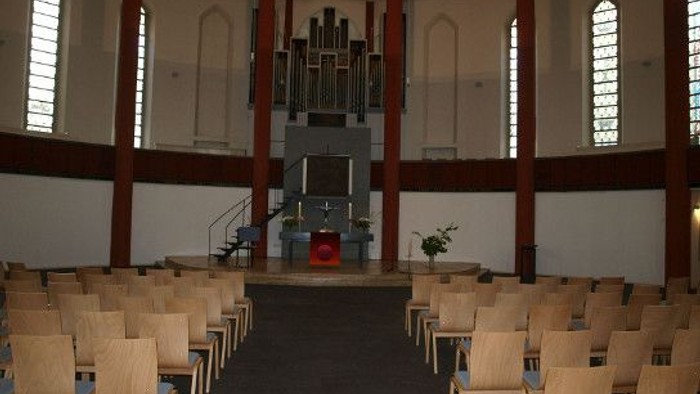 Leere Kirche mit Holzstühlen und Orgel