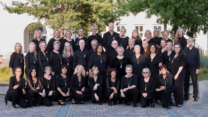 Amazing Voices in schwarzer Konzertkleidung vor einem Gebäude