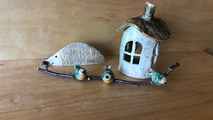 Verspieltes Keramikhaus mit Vögeln und Früchten auf einem Ast.