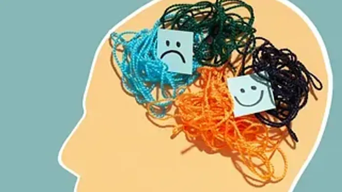 Et sammenfiltret sind med smilende og sure ansigter blandt farverigt garn, der symboliserer modstridende følelser eller tanker.