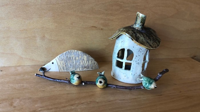 Verspieltes Keramikhaus mit Vögeln und Früchten auf einem Ast.