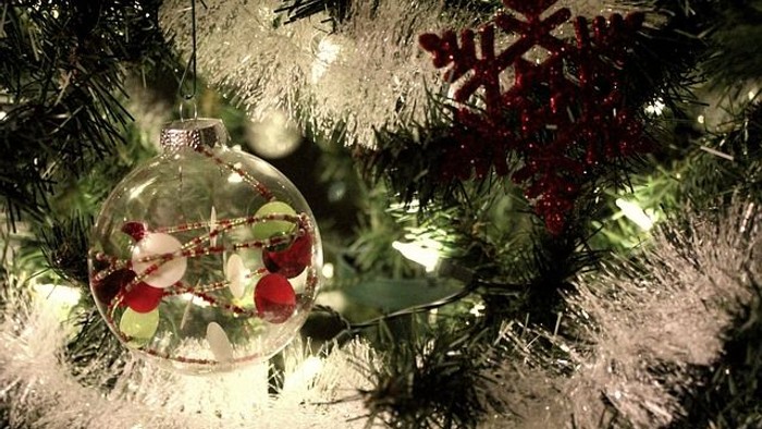 En juledekorationskugle med en lille snefloke og lys på en juletree