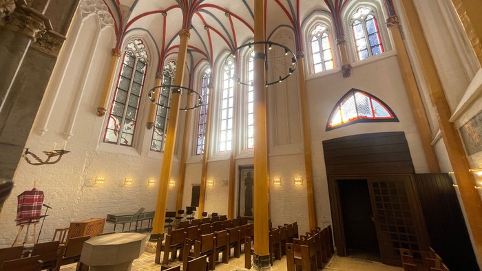 Großzügige Kircheninneraum mit hohen Decken und Buntglasfenstern