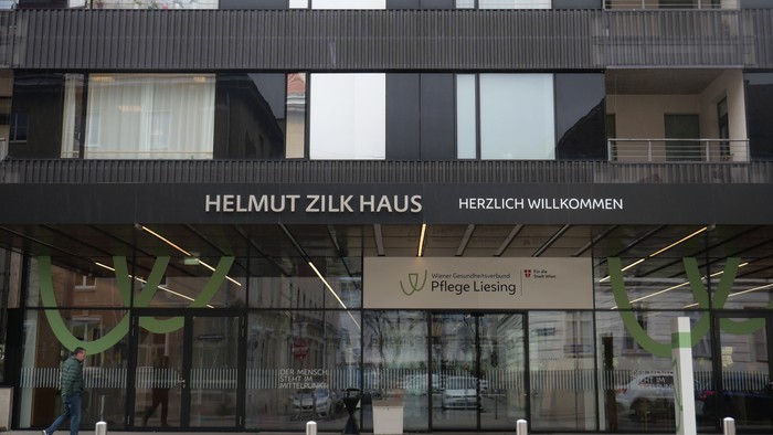 Das Gebäude Helmut Zilk Haus mit grünen Akzenten und Schildern.