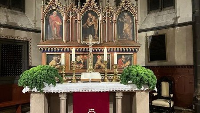 Altar in gotischer Kirche mit goldenen Reliquien und grünen Pflanzen