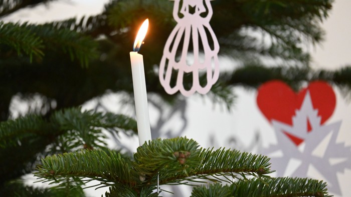 En lysende lykt på en juletree med hjerte- og snestjerner.