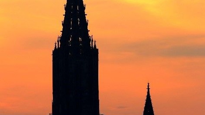 Im Abendrot leuchten die Silhouetten der Kathedraltürme vor einem leuchtenden Sonnenuntergangshimmel.