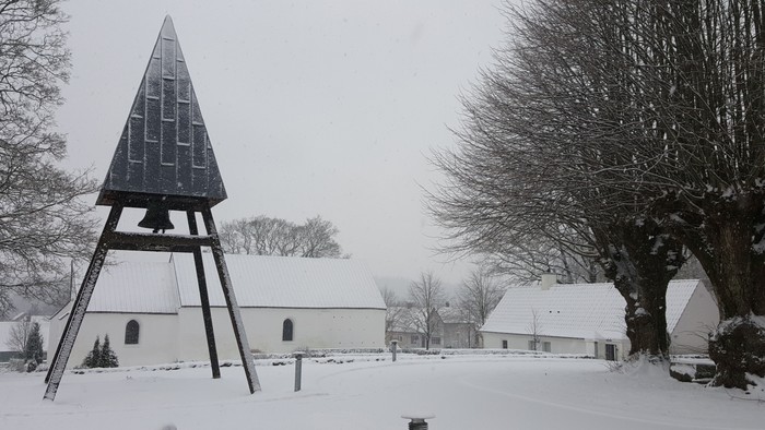 En snødekt landsby med en trætoret og en kirke