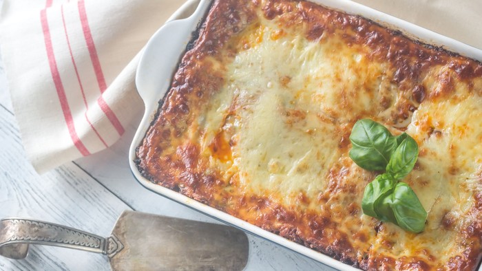 En lasagne i en pyxis med frisk basilikum på toppen