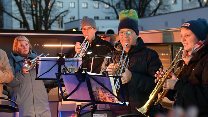 Jazzmusiker, die während einer Abendveranstaltung auf einer Bühne Blechblasinstrumente spielen.