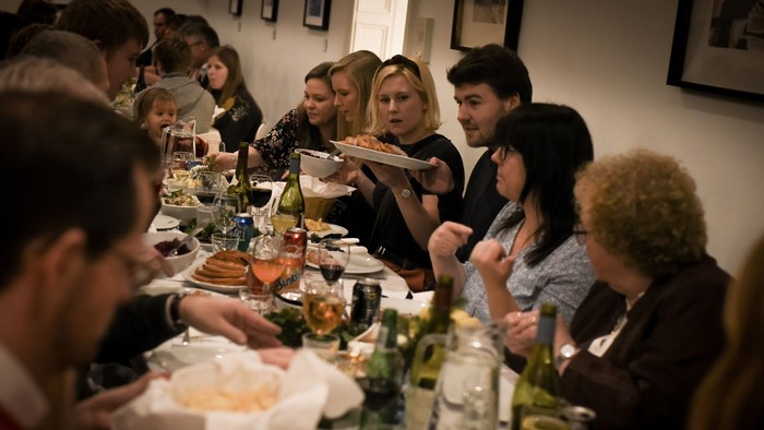 En gruppe af mennesker sidder sammen ved et bord og spiser.