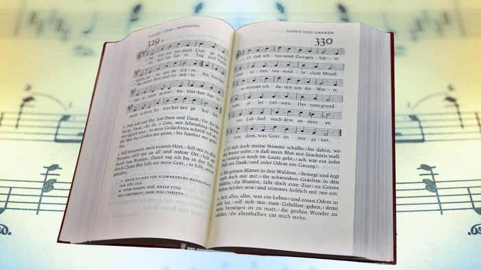 Gesangbuch, dahinter farbige Noten