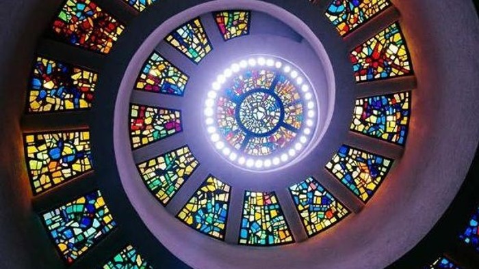 Lebendige runde Buntglasfenster strahlen Licht in einem atemberaubenden spiralförmigen Architekturdesign aus.