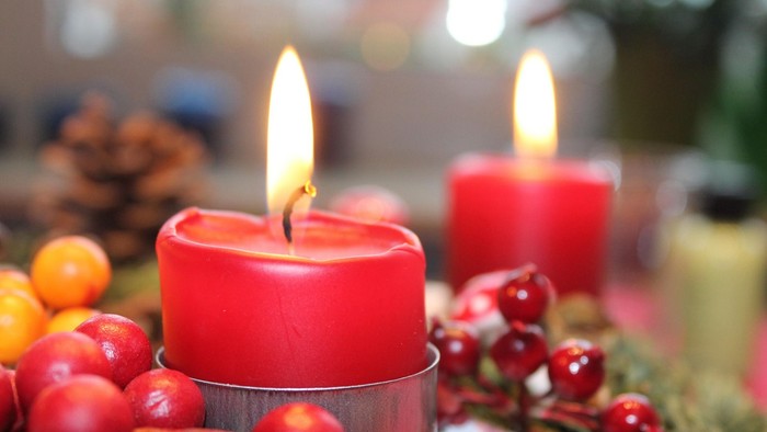 Zwei brennende Kerzen mit Adventsschmuck