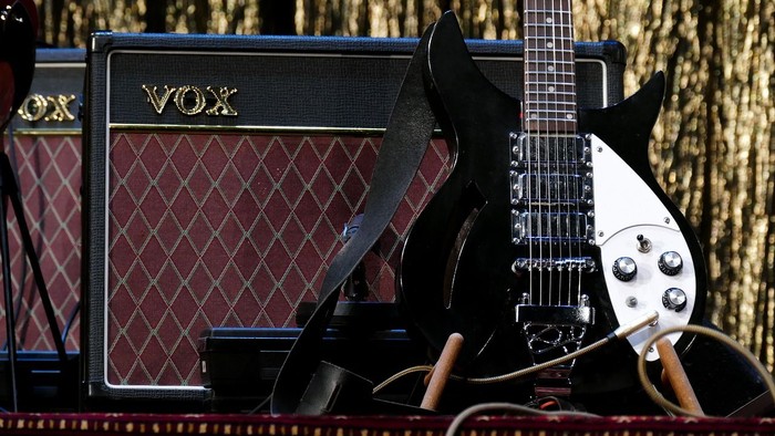 E-Gitarre, die an einem Vox-Verstärker auf der Bühne lehnt.