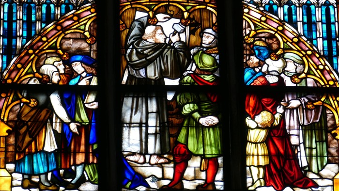 Reformationsfenster in einer Kirche - Luther schlägt seine Thesen an.