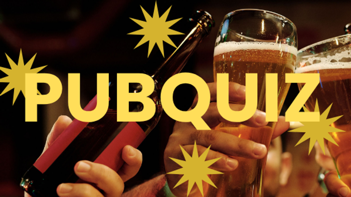 En livlig pub-quiz-scene med folk, der holder drinks og øl, og fejrer med festlige gule stjernepynt.