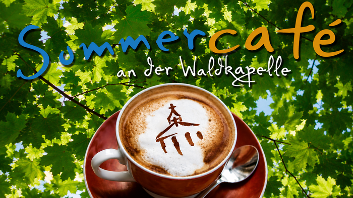 Eine Kaffeetasse auf einer Untertasse steht vor einem grünen Blätterdach. Im Milchschaum ist das Motiv einer kleinen Kapelle zu sehen, darüber steht der Schriftzug „Sommercafé an der Waldkapelle“.