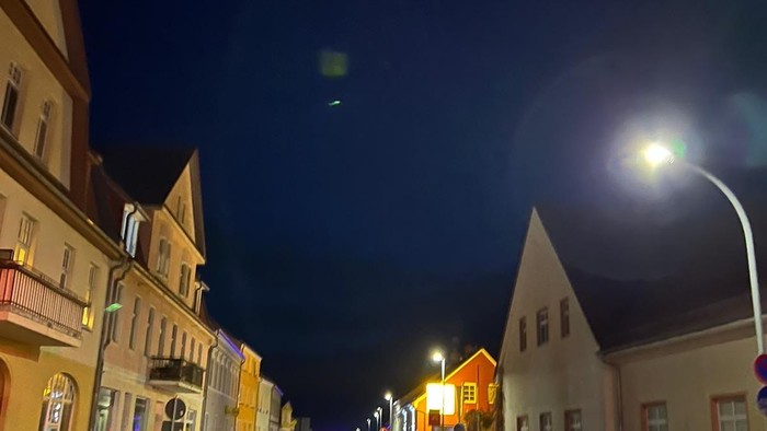 Menschen feiern bei Nacht auf einer belebten Straße