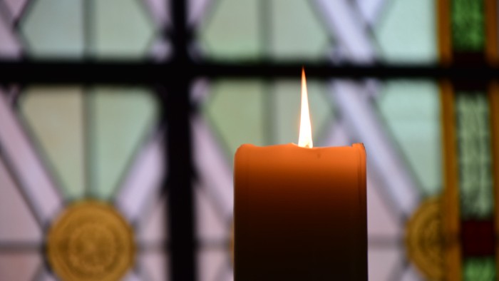 Brennende Kerze vor Kirchenfenster in Zossen