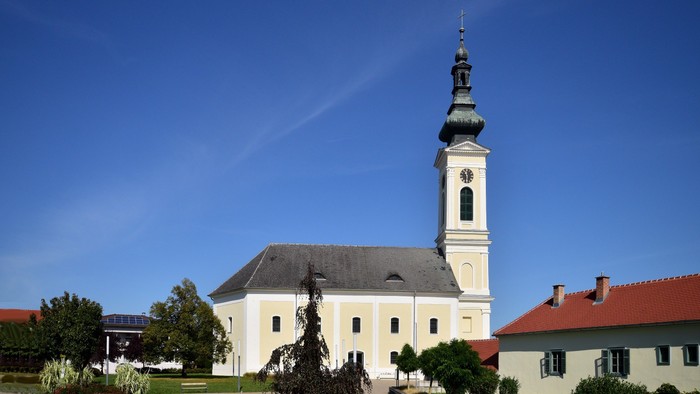 Weiße Kirche mit hohem Turm und blauen Himmel