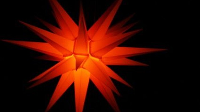 Ein leuchtender orangefarbener Stern vor schwarzem Hintergrund