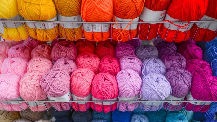 Wollknäule in verschiedenen Farben in einem Regal