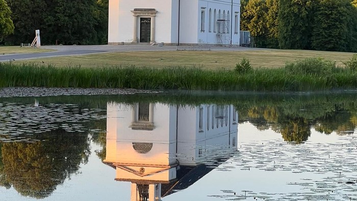 En lille kirke ved en sø i en park